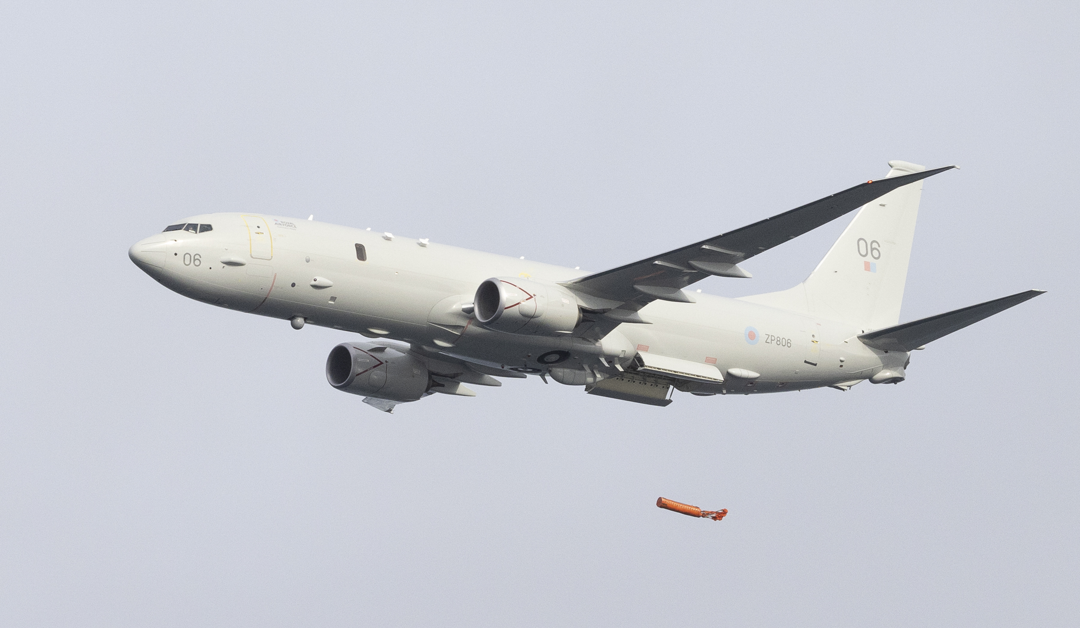 Image shows RAF Poseidon aircraft in flight deploying cargo load.